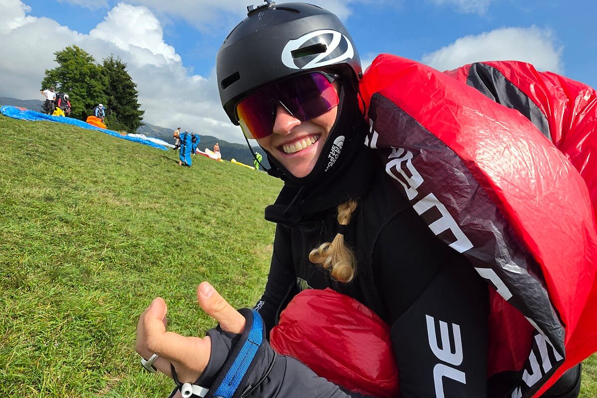 Viele Teilnehmende sitzen und stehen auf einer Wiese und hören einer Person mit Papier in der Hand zu.