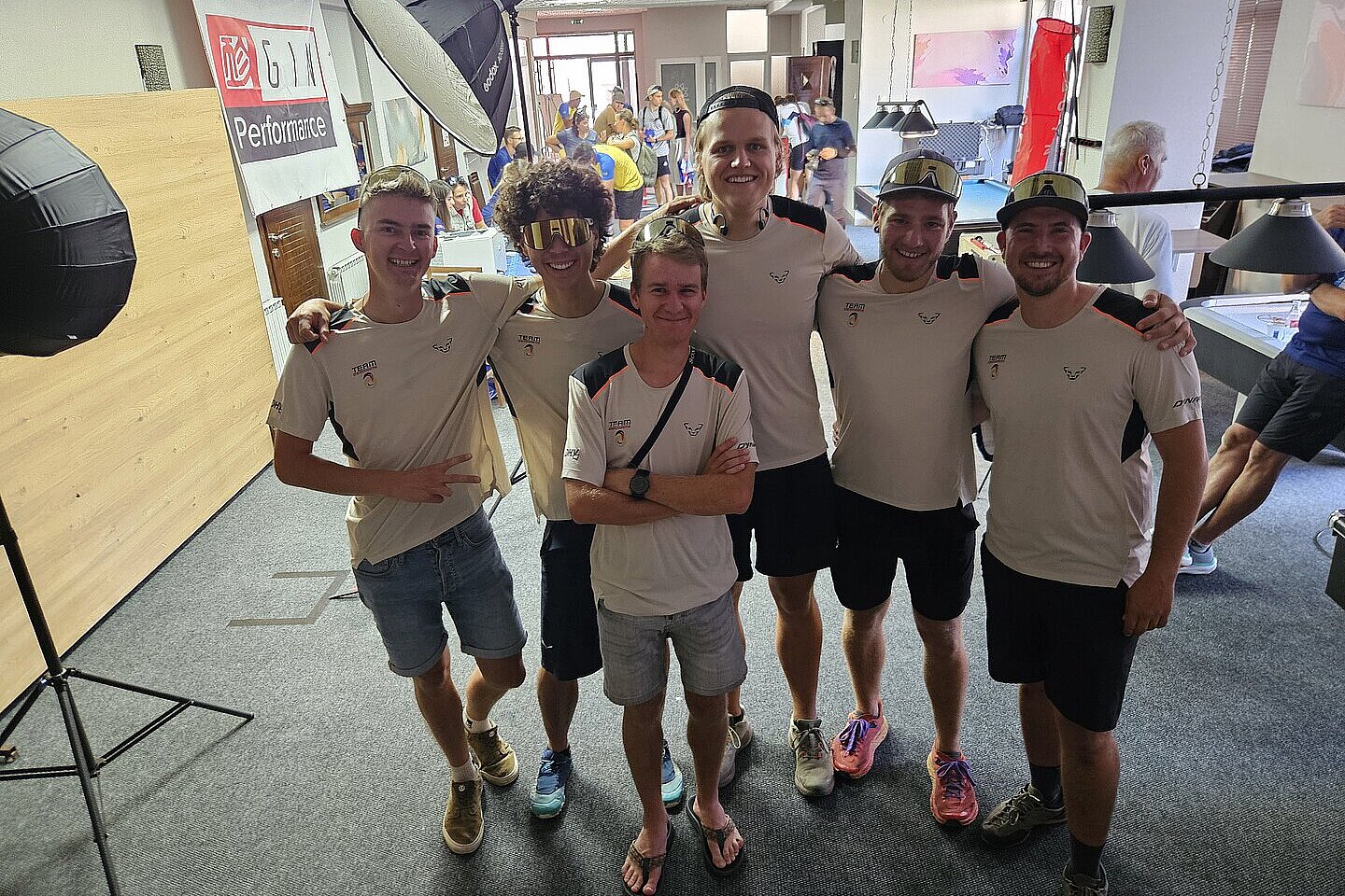 Mehrere Teammitglieder stehen im Gebäude nebeneinander und lächeln für ein Gruppenfoto.