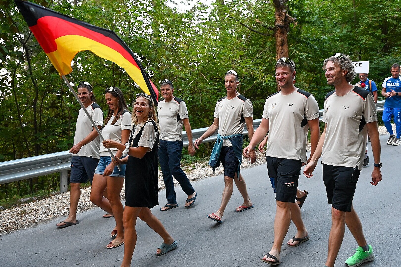 Gruppe in Tracht posiert mit Trommeln vor einem Gebäude.