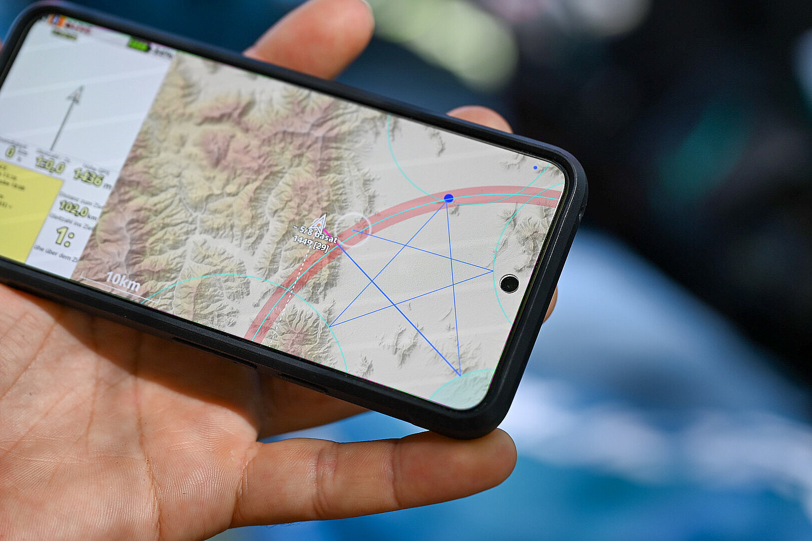 Hand hält ein Smartphone mit einer Kartenansicht.