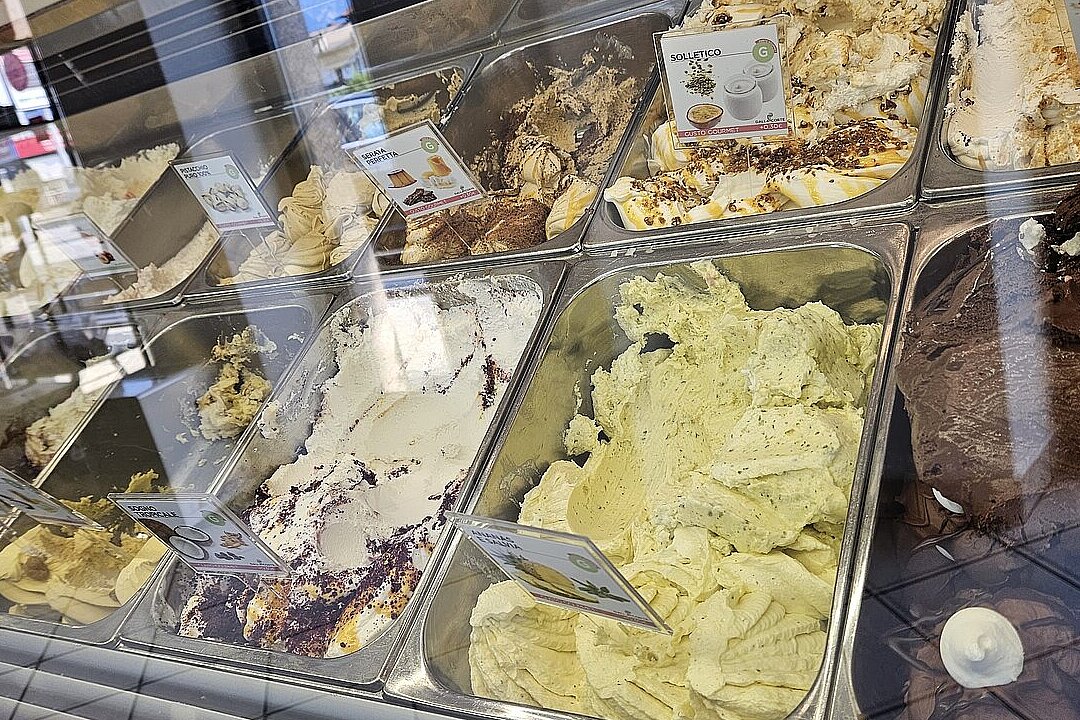 Offene Eisvitrine mit verschiedenen Sorten Eis in einer Eisdiele.