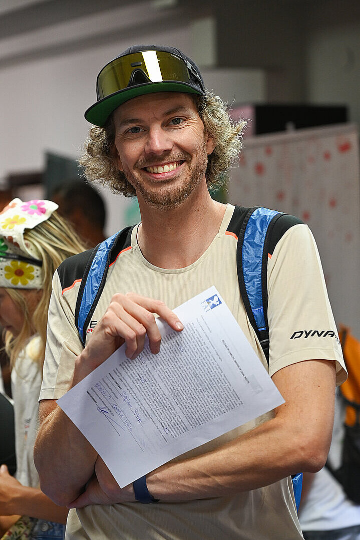 Lachender Mann hält ein Formular in der Hand.